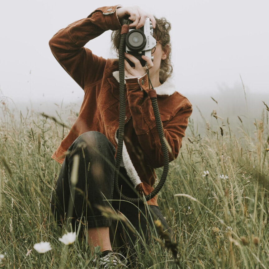 A woman with a camera in a meadow