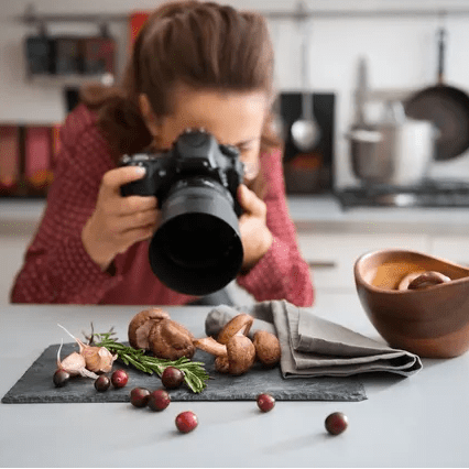 A woman taking a photo of food on a table
